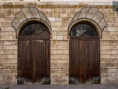 Pochi passi e facciamo un nuovo salto nel tempo. Sulla facciata del teatro Traetta in tre diversi punti si intravede...